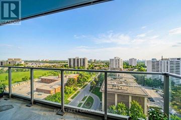 Toronto (Henry Farm) condo for rent - A view from a balcony overlooking a cityscape with buildings and a road.