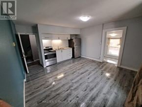 Orillia apartment for rent - A kitchen with a refrigerator, oven, and sink is shown in a real estate listing.