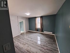 Orillia apartment for rent - A room with a wooden floor and a window with curtains.