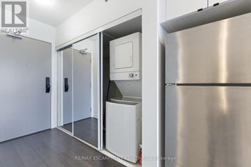 Burlington (Alton) condo for rent - A stainless steel refrigerator is in a kitchen with white cabinets.