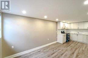 Mississauga (Meadowvale) apartment for rent - A well-lit, empty room with a kitchenette and wooden flooring.