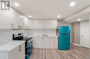 Mississauga (Meadowvale) apartment for rent - A kitchen with white cabinets and a blue refrigerator.