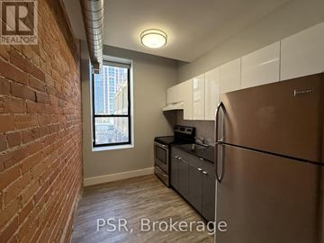 Toronto (Junction Area) condo for rent - A kitchen with a stainless steel refrigerator and wooden flooring.