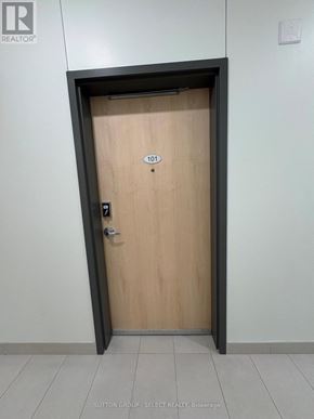 London East (East K) condo for rent - A door with a number 101 on it is in a hallway.