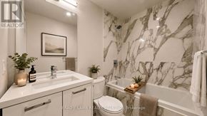 Toronto (Moss Park) condo for rent - A bathroom with marble walls and a white toilet.