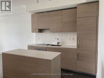 Toronto (Annex) condo for rent - A kitchen with brown cabinets and a white countertop.