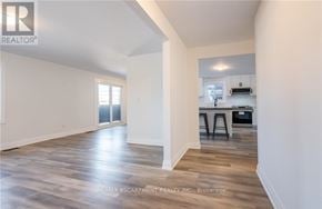 Lincoln (Beamsville) apartment for rent - A spacious room with wooden flooring and white walls.
