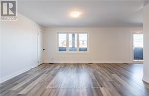 Lincoln (Beamsville) apartment for rent - A spacious room with wooden flooring and a large window.