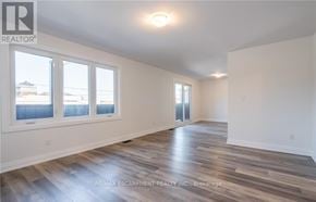 Lincoln (Beamsville) apartment for rent - A spacious room with wooden flooring and white walls.