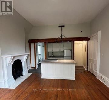 Brockville multi-family for rent - A large open room with a fireplace and a kitchen area.