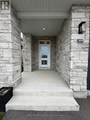 Loyalist (Amherstview) apartment for rent - The entrance to a home with a stone pillar and a glass door.