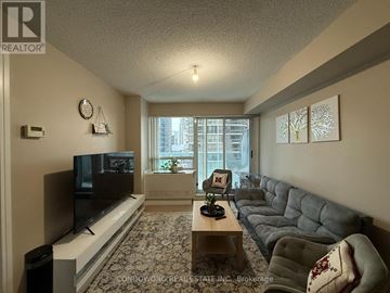 Toronto (Willowdale East) condo for rent - A living room with a grey couch and a flat screen TV.