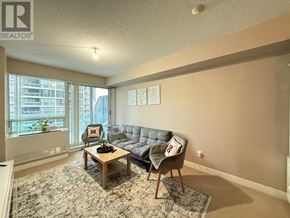 Toronto (Willowdale East) condo for rent - A living room with a grey couch and a wooden coffee table.