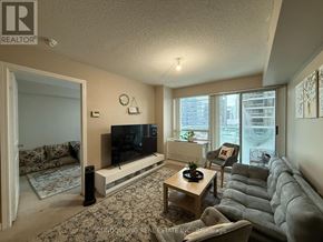 Toronto (Willowdale East) condo for rent - A living room with a grey couch and a flat screen TV.