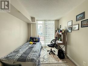 Toronto (Willowdale East) condo for rent - A bedroom with a bed, desk, chair, and window.