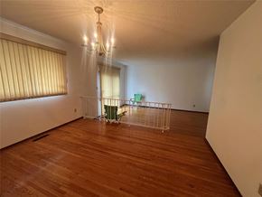 Winnipeg apartment for rent - A room with wooden floors and a chandelier.