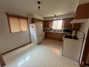 Winnipeg apartment for rent - A kitchen with white appliances and a white tiled floor.