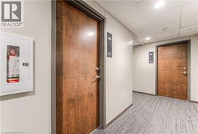 Kitchener condo for rent - A hallway with a wooden door and a sign that says REALTOR.
