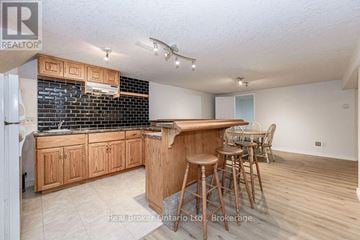 Guelph (Dovercliffe Park/Old University) apartment for rent - A kitchen with wooden cabinets and a bar area.