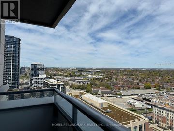 Markham (Unionville) condo for rent - A view from a balcony overlooking a cityscape with buildings and a construction crane.