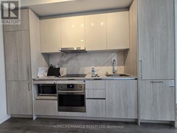 Vaughan (Vaughan Corporate Centre) condo for rent - A modern kitchen with a marble backsplash and stainless steel appliances.