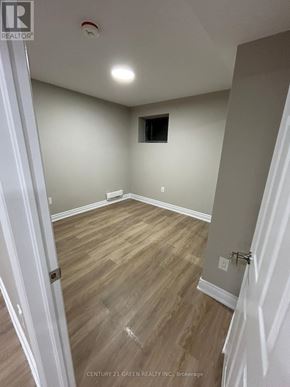 Oshawa (Kedron) apartment for rent - A room with wooden flooring and white walls.