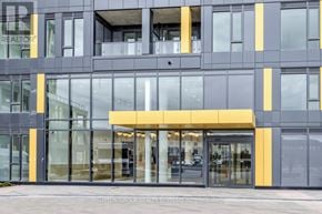 Burlington (Alton) condo for rent - A modern building with a yellow and grey facade and glass doors.