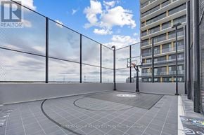 Burlington (Alton) condo for rent - A rooftop terrace with a fence and a building in the background.