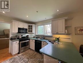 Markham (Bullock) apartment for rent - A kitchen with white cabinets and black appliances.