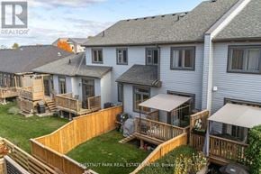 Prince Edward County (Picton Ward) townhouse for rent - A real estate company is advertising a property with a well-maintained lawn and deck.