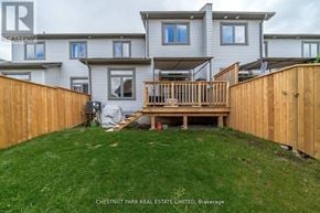 Prince Edward County (Picton Ward) townhouse for rent - A house with a wooden fence and a deck in the backyard.