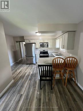Welland (N. Welland) apartment for rent - A kitchen with a refrigerator, stove, and microwave.
