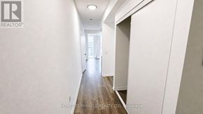 Burlington (Alton) condo for rent - A long hallway with a door on the right and a window on the left.