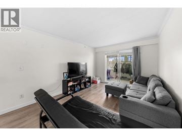 Vancouver apartment for rent - A living room with a grey couch and a television.