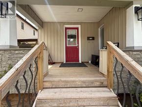 Niagara Falls (Hospital) apartment for rent - A red door is on the left side of a wooden porch.