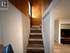 Niagara Falls (Hospital) apartment for rent - A staircase in a house with a brokerage logo on the wall.