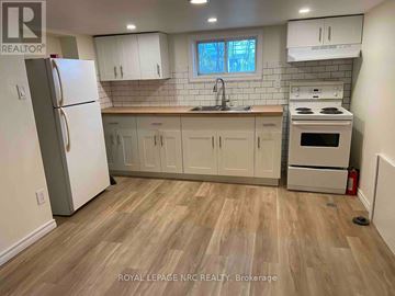 Niagara Falls (Hospital) apartment for rent - A kitchen with a refrigerator, cabinets, and a stove top oven.