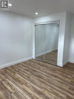 Ottawa apartment for rent - A room with a wooden floor and a sliding glass door.