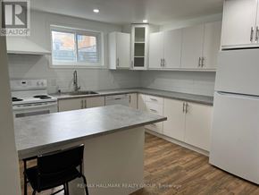 Ottawa apartment for rent - A kitchen with white cabinets and a marble countertop.