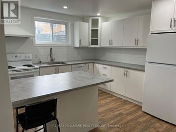 Ottawa apartment for rent - A kitchen with white cabinets and a marble countertop.