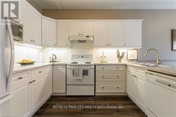 London North (North B) townhouse for rent - A clean, white kitchen with a refrigerator, oven, and sink.