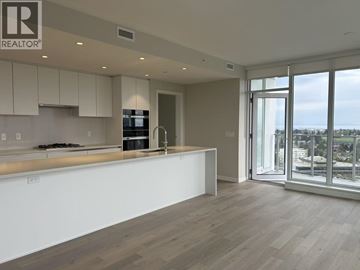 Vancouver apartment for rent - A modern kitchen with white cabinets and a large island.