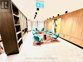 Toronto (Mimico) condo for rent - A conference room with a table surrounded by chairs and a sign above it.