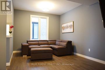 London North (North M) house for rent - A living room with a brown couch and a painting on the wall.