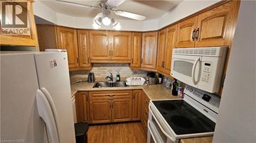 Kitchener condo for rent - A kitchen with wooden cabinets and a white fridge.