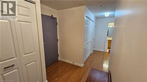 Kitchener condo for rent - A room with a wooden floor and white walls.