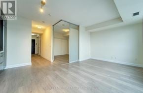 Toronto (Willowdale East) condo for rent - A spacious room with wood flooring and a large mirror on the wall.
