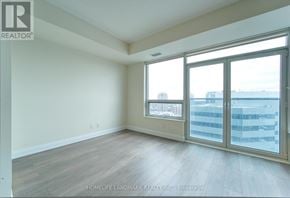 Toronto (Willowdale East) condo for rent - A room with a view of a city skyline through large windows.