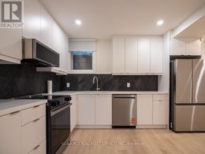 Toronto (Junction Area) apartment for rent - A modern kitchen with white cabinets and stainless steel appliances.