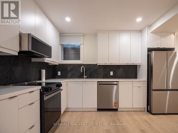 Toronto (Junction Area) apartment for rent - A modern kitchen with white cabinets and stainless steel appliances.